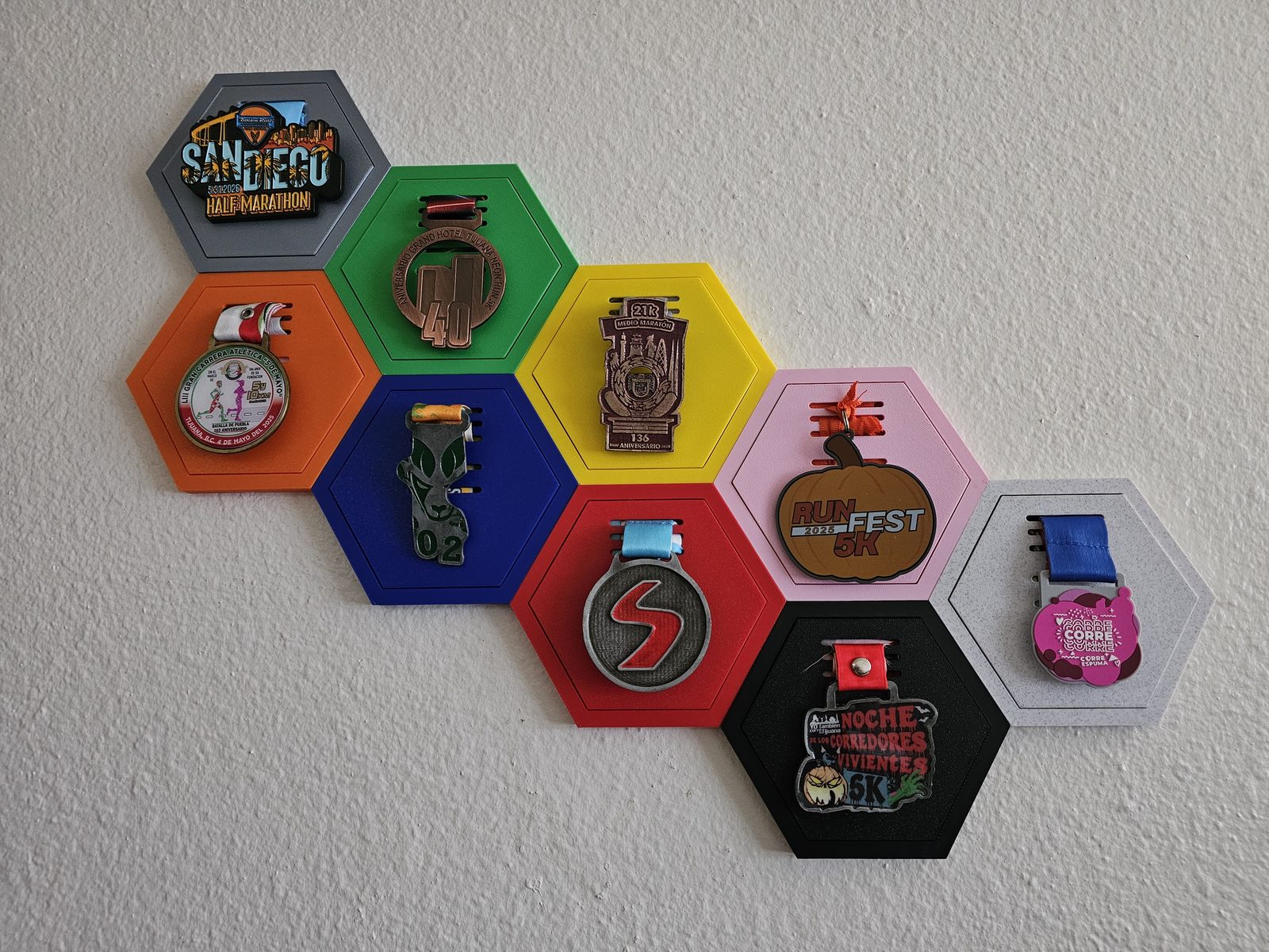 A growing multi-color Hive Medal Co. wall holding a full race medal collection